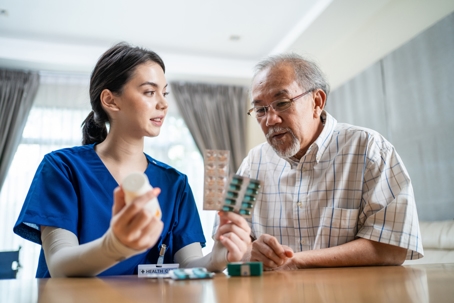 nurse showing medication to an elderly man