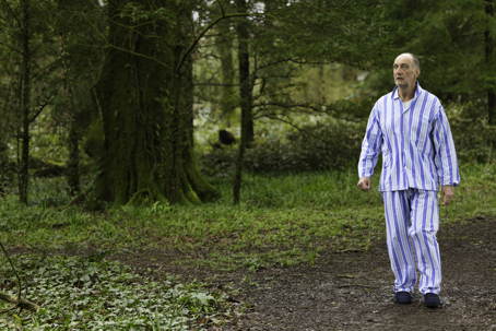 older man in pajamas wandering outside