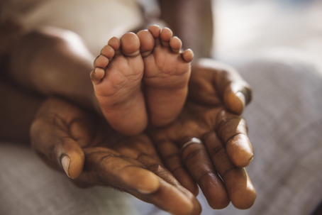person holding infant's feet